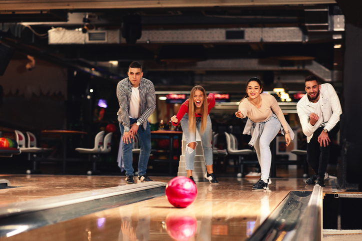 A group of friends cheer on a bowler A group of friends cheer on a bowler